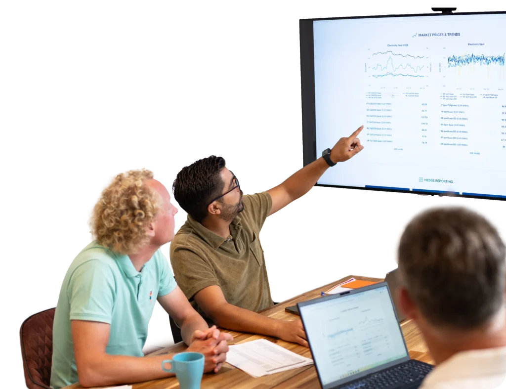 Drie personen analyseren energieprijs- en trendgegevens gepresenteerd op een scherm tijdens een vergaderbijeenkomst.