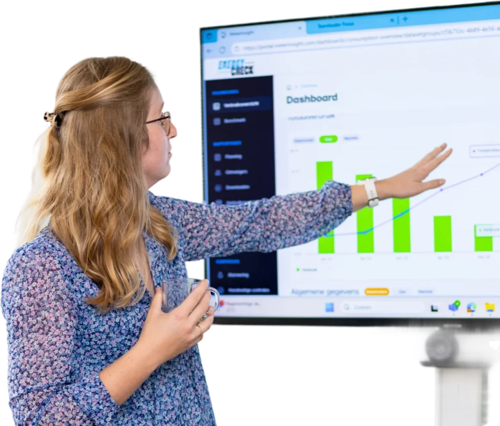 Een vrouw geeft een presentatie met een scherm waarop een dashboard met energiedata en grafieken wordt getoond.